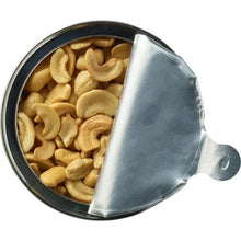 Canister lid open to salted cashew halves and pieces with silver inner seal