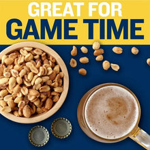 Bowl of salted peanuts with scattered peanuts and cup of drink