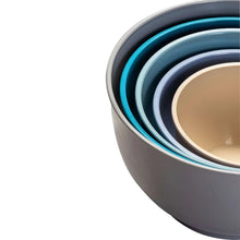 Side view of nesting plastic mixing bowls with teal and beige inner bowl
