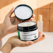 Open hair masque jar with white cream, held in a hand