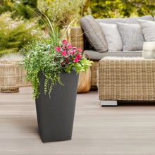 Slate black planter pot with pink flowers on an outdoor patio