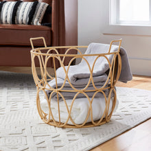 Rattan-style storage basket with handles, light tan woven lattice, holding a folded blanket