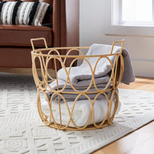 Woven poly rattan storage basket with handles holding white and gray textiles