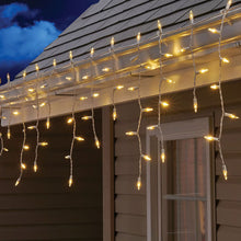 Warm white LED icicle lights hanging along a roof eave