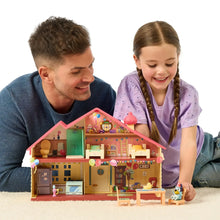Toy playset house with colorful interior rooms, held by a child and parent
