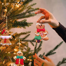 Hand holding a gingerbread man ornament with red bow and striped details