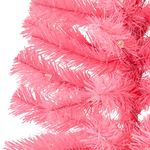 Close-up of pink artificial Christmas tree tips with warm white LED bulbs