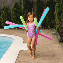 Foam pool noodles in pink, green, and blue held by child near pool