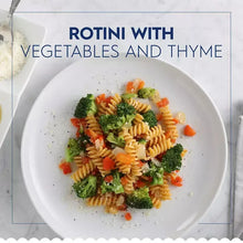 Plate of rotini pasta with vegetables and thyme in a white bowl
