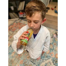 Boy drinking from Apple & Eve apple juice bottle