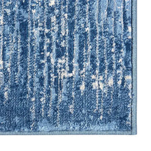 Blue and white distressed area rug with vertical stripe-like texture, short low pile