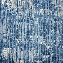 Blue area rug close-up with distressed abstract lines and speckled low-pile texture