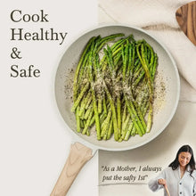 White granite nonstick skillet with roasted asparagus inside, wooden spatula nearby