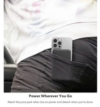 Wireless magnetic power bank attached to phone in a front jeans pocket