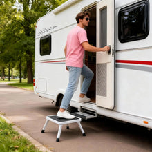 Foldable 1-step stool with black platform and carry handle, positioned beside an RV step.