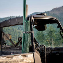 Black rubber utility strap looped around a vehicle bar, adjustable hole section visible.