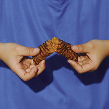 Broken Zbar chocolate chip soft-baked snack bars held between hands
