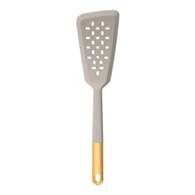 Silicone slotted turner utensil in gray with gold-tone handle and hanging loop