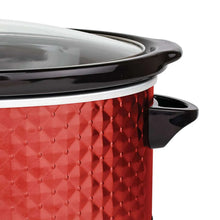 Red slow cooker with black lid rim and glossy glass lid, showing textured pot side.