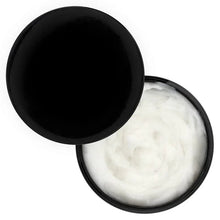 Hair masque jar with black lid open and white cream inside