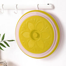 Yellow vented microwave splatter cover with flower-like perforated pattern