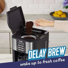 Open programmable coffee maker with filter basket holding coffee grounds