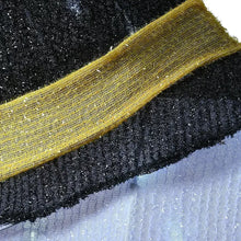 Black witch hat with yellow ribbon band on pre-lit candy corn decoration