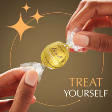 Hands unwrapping a Lindor chocolate truffle candy