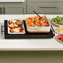 Electric warming tray with food pans on the black heating plate