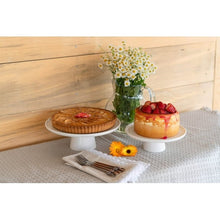 Two-tier white cake stand with desserts on the top and bottom tiers