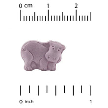 Purple chewable tablet next to size ruler