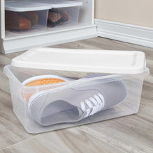 Clear plastic storage bin with white snap-on lid holding shoes, on shelving