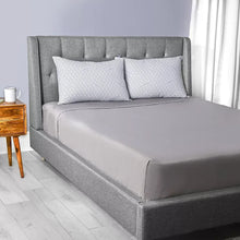 Set of two geometric pattern pillows on a gray bedspread