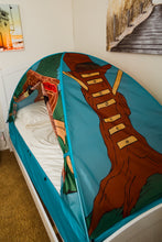Treehouse pop-up bed tent with blue base, white interior bed, green roof and brown walls