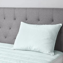 Light blue rectangular pillow on bed, smooth cushion with stitched seams