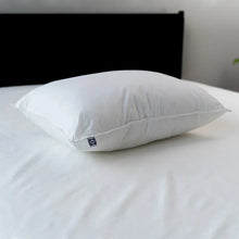 White pillow on top with visible corner seam and brand tag
