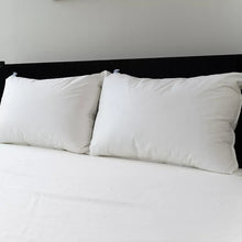 Two white pillows with stitched edges and corner brand tags