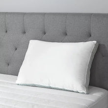 White pillow with striped gusset edge on a bed