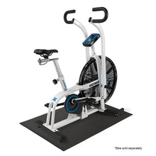 Fitness equipment mat, dark gray, on floor under stationary bike