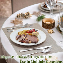 Stainless steel flatware set on a dining table with knife and spoon near a plate