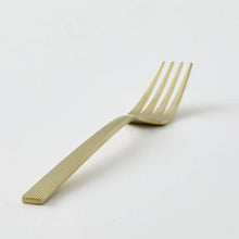 Gold stainless steel fork with ridged handle and four tines