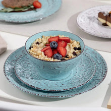 Turquoise stoneware bowl and plate with embossed design, filled with fruit.