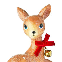 Sitting deer tabletop decoration close-up, brown glitter face with red bow and bell