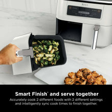 Dual-basket air fryer with open basket holding broccoli and browned chicken pieces
