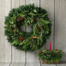 Evergreen wreath with pinecones, red berries, and cinnamon stick accents