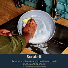 Blue ceramic non-stick fry pan being scrubbed with a sponge