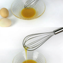 Stainless balloon whisk stirring egg mixture in a glass bowl