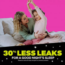 Girls and mother in light pink pajama set while lying in bed