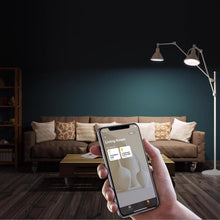 Smart LED bulb in lamp fixture, smartphone app shown for control