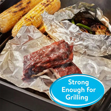 Foil-covered grill pan with corn and grilled meat under crinkled aluminum foil